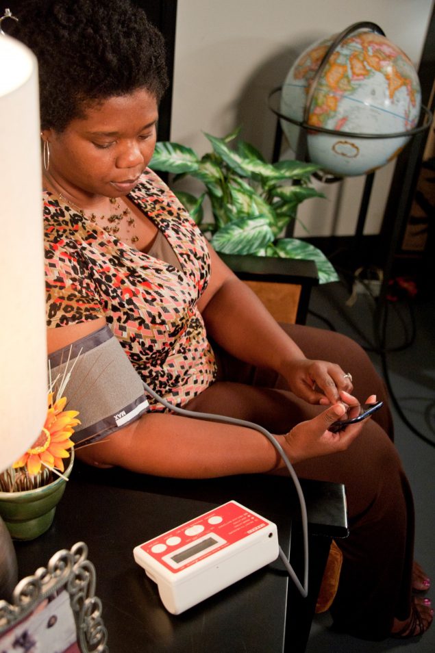 about-bp Woman using a home blood pressure monitor.